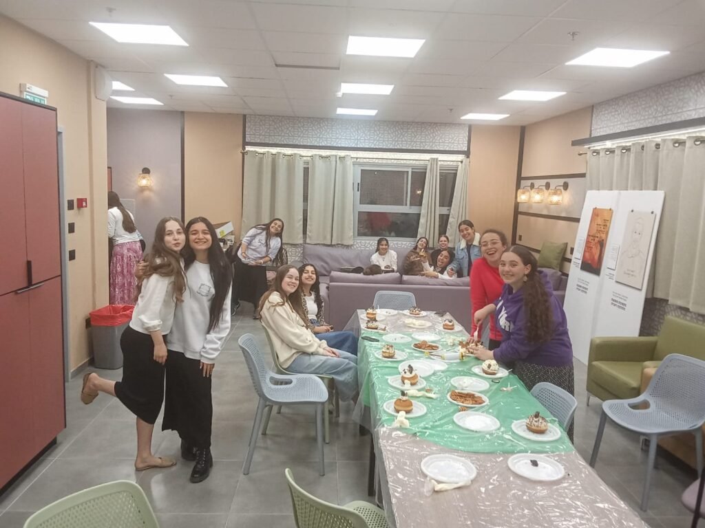 בנות הפנימייה סביב שולחן סופגניות בחדר המשותף